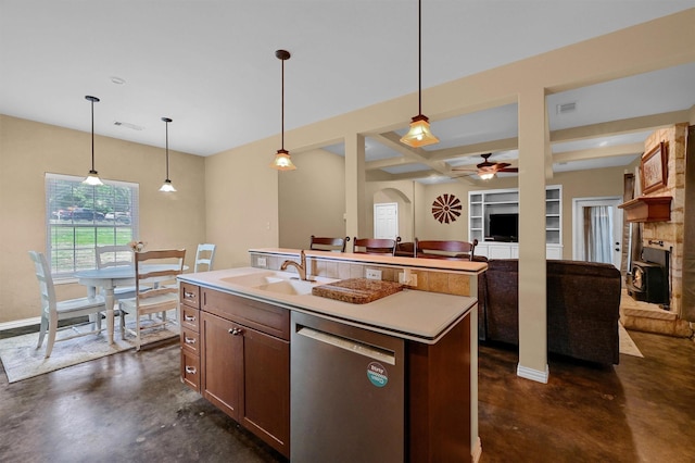 kitchen with sink, dishwasher, a fireplace, a center island with sink, and decorative light fixtures