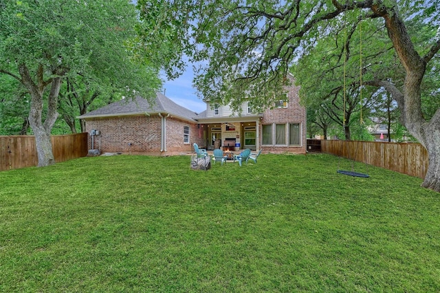 rear view of house featuring a lawn and an outdoor fire pit