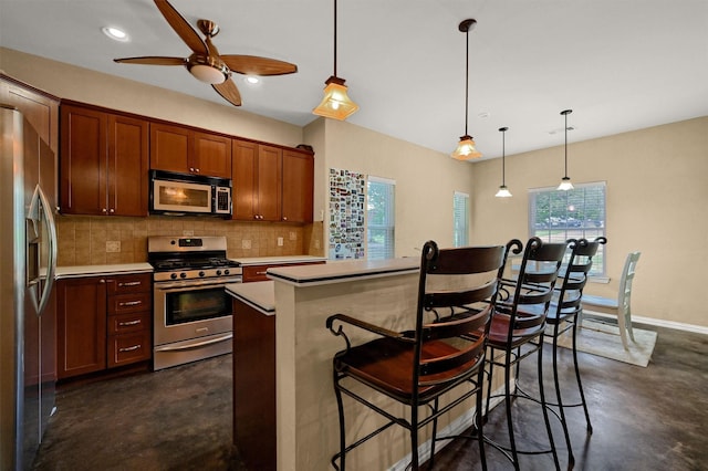 kitchen featuring tasteful backsplash, stainless steel appliances, a breakfast bar area, and hanging light fixtures