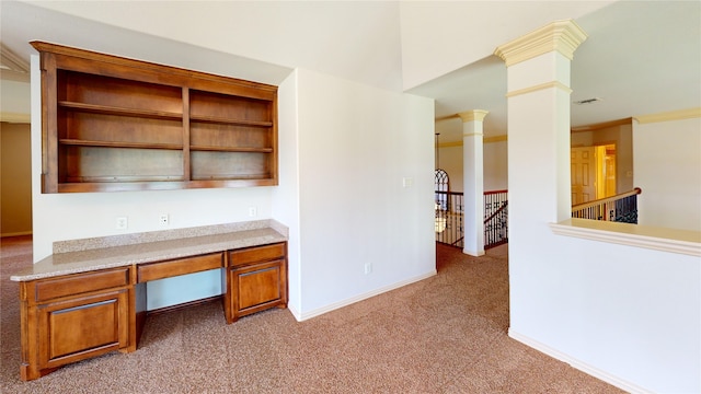 unfurnished office featuring crown molding, built in desk, light carpet, and ornate columns