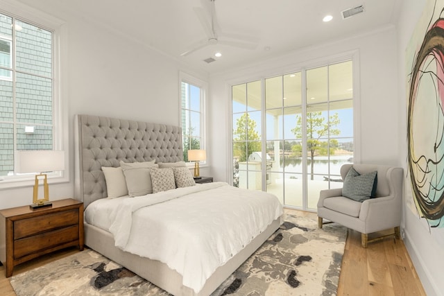 bedroom with a water view, crown molding, light hardwood / wood-style flooring, access to outside, and ceiling fan