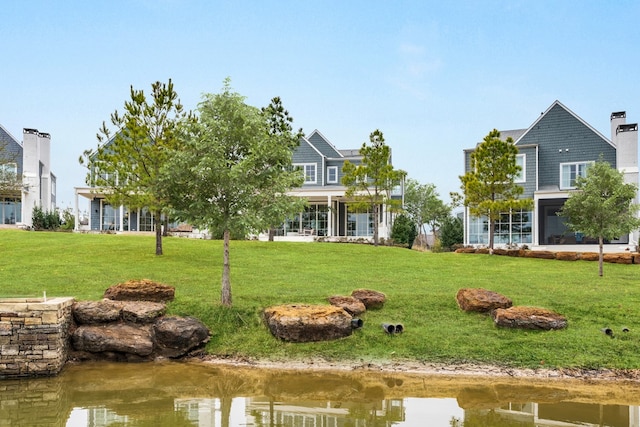 exterior space with a water view and a front lawn