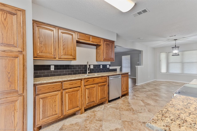 kitchen featuring sink, decorative light fixtures, a textured ceiling, dishwasher, and backsplash