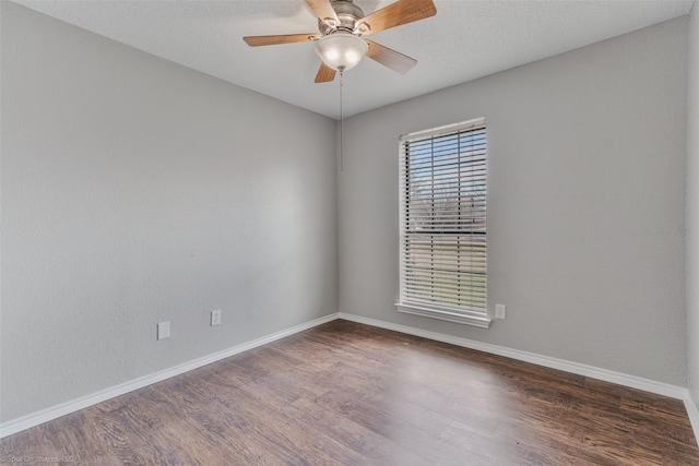 spare room with dark wood-type flooring, a textured ceiling, and ceiling fan