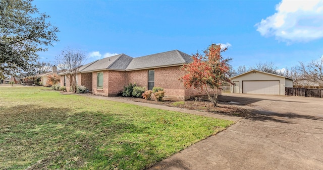 view of front of house featuring a garage, an outbuilding, and a front lawn