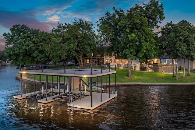 dock area with a water view and a yard