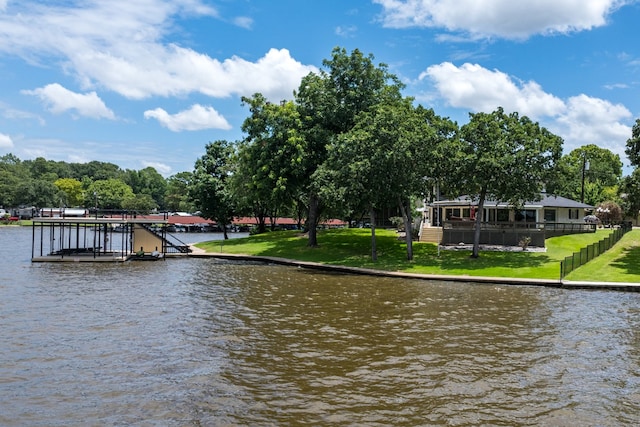 water view with a dock, boat lift, and fence