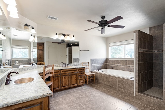 full bath with visible vents, a ceiling fan, a tile shower, vanity, and a bath