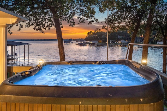 exterior space with a hot tub and a water view