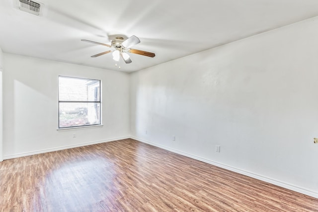 empty room with hardwood / wood-style floors and ceiling fan