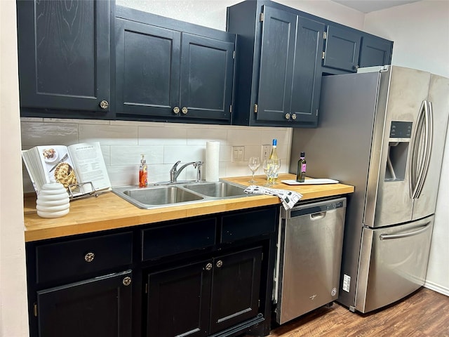 128 Black Forest Dr, Weatherford, TX 76086 - kitchen featuring wood finished floors, stainless steel appliances, butcher block counters, tasteful backsplash, and a sink