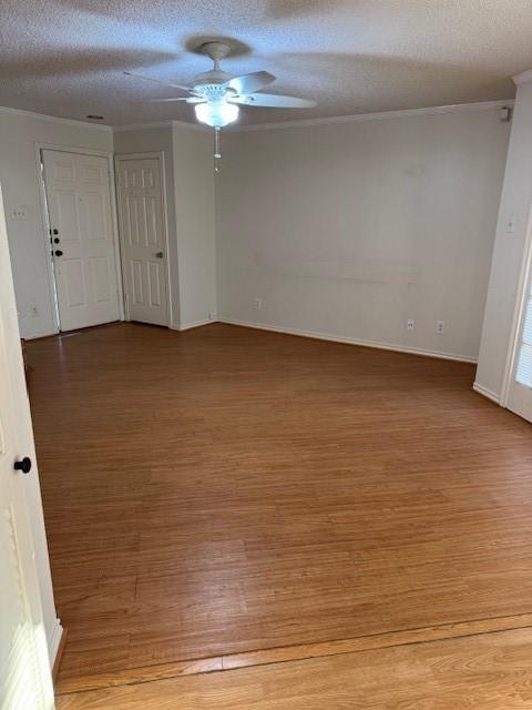 unfurnished room featuring crown molding, ceiling fan, wood-type flooring, and a textured ceiling