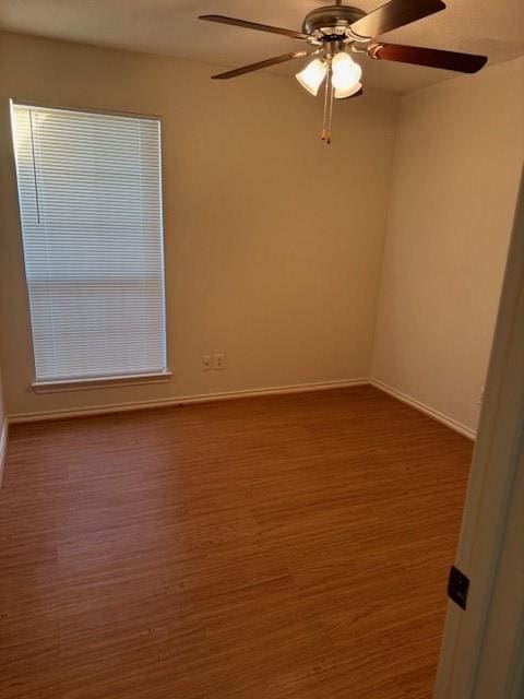 spare room featuring dark wood-type flooring and ceiling fan