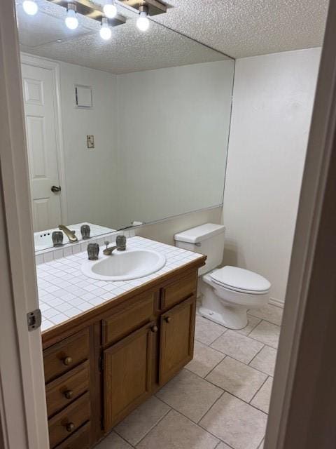 bathroom featuring tile patterned flooring, vanity, and a textured ceiling