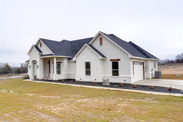 modern inspired farmhouse with a garage, a front yard, and cooling unit