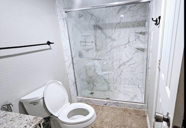 bathroom featuring a shower with door and toilet