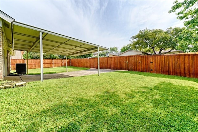 view of yard with central AC and a patio