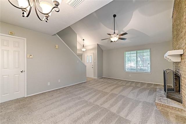 unfurnished living room with ceiling fan with notable chandelier, a fireplace, vaulted ceiling, and light carpet