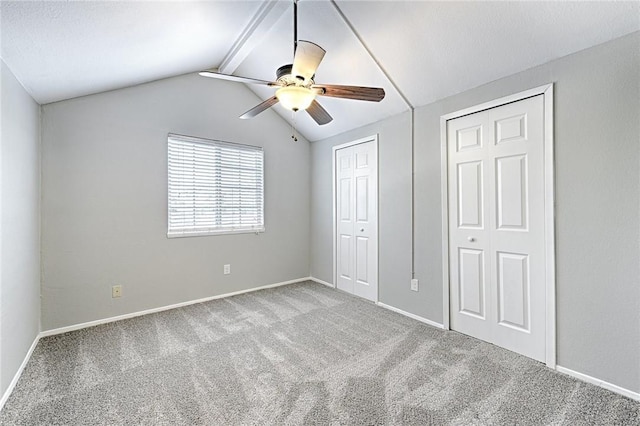 unfurnished bedroom featuring vaulted ceiling with beams, light colored carpet, and ceiling fan