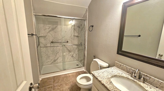 bathroom with vanity, toilet, a shower with shower door, and tile patterned flooring