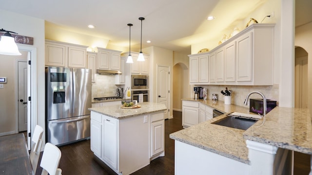 kitchen with white cabinetry, decorative light fixtures, stainless steel appliances, and a kitchen island