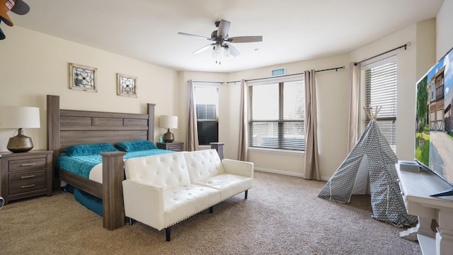 bedroom featuring multiple windows, light colored carpet, and ceiling fan