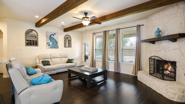 living room featuring a fireplace, dark wood-type flooring, beamed ceiling, and ceiling fan