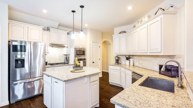 kitchen featuring white cabinetry, light stone counters, decorative light fixtures, and appliances with stainless steel finishes