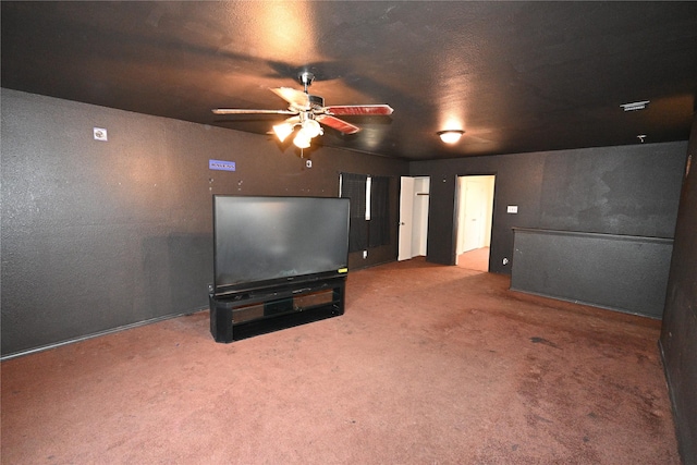 carpeted cinema with ceiling fan and a textured ceiling