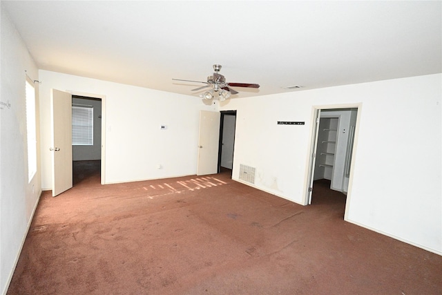 unfurnished bedroom with ceiling fan and dark colored carpet