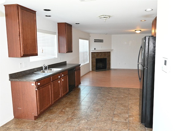 kitchen featuring sink, a fireplace, and black appliances