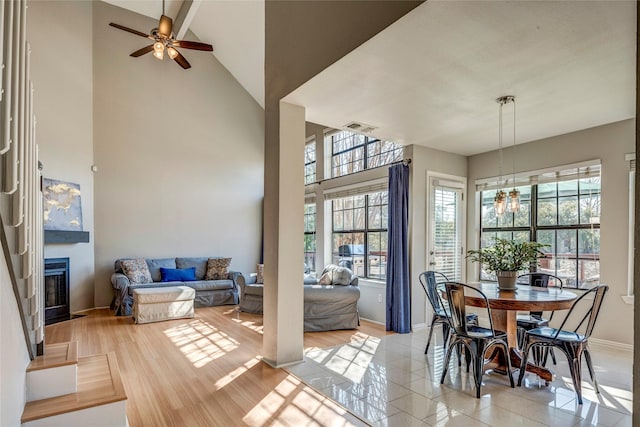 tiled dining area with a towering ceiling and ceiling fan