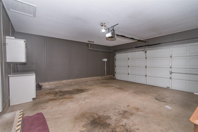 garage featuring a garage door opener and fridge