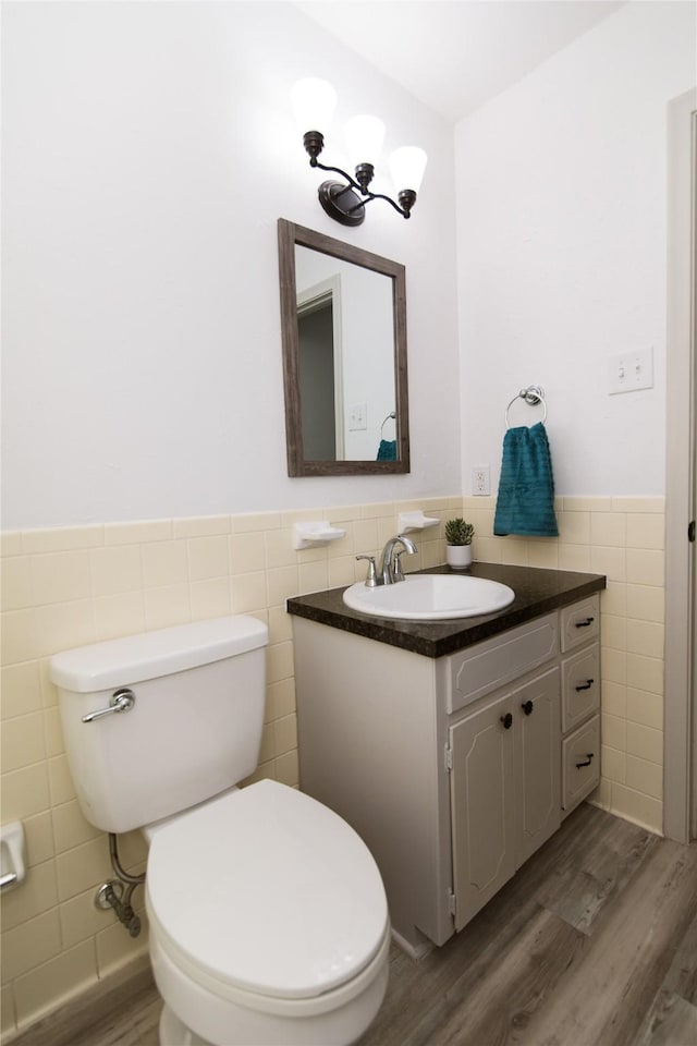 bathroom with vanity, hardwood / wood-style floors, toilet, and tile walls