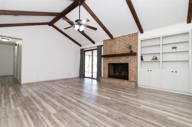 unfurnished living room with a brick fireplace, lofted ceiling with beams, light hardwood / wood-style floors, and ceiling fan