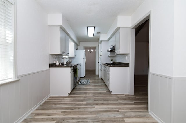 kitchen featuring white cabinetry, dishwasher, white fridge, a notable chandelier, and light wood-type flooring