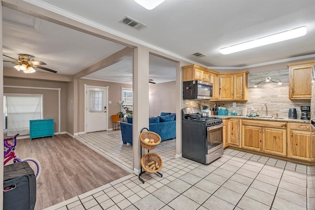 kitchen featuring light tile patterned flooring, sink, tasteful backsplash, ornamental molding, and appliances with stainless steel finishes