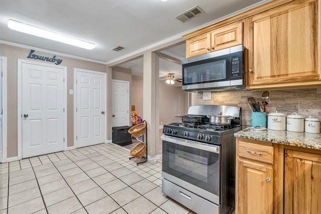 kitchen with light tile patterned floors, stainless steel appliances, light stone counters, ornamental molding, and decorative backsplash