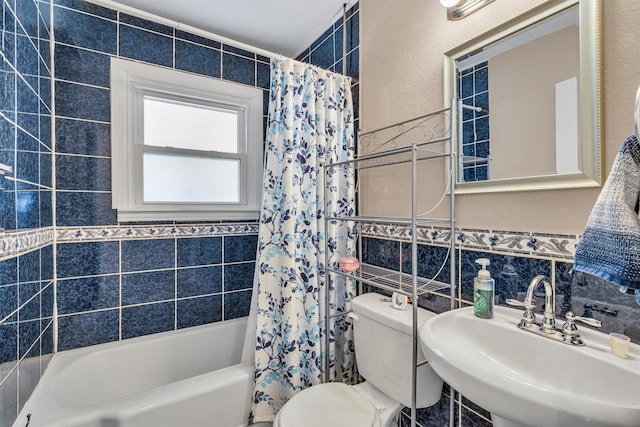 full bathroom with shower / tub combo with curtain, sink, tile walls, decorative backsplash, and toilet