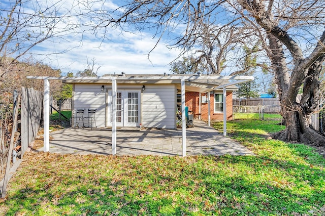 rear view of property featuring french doors, a yard, and a patio area