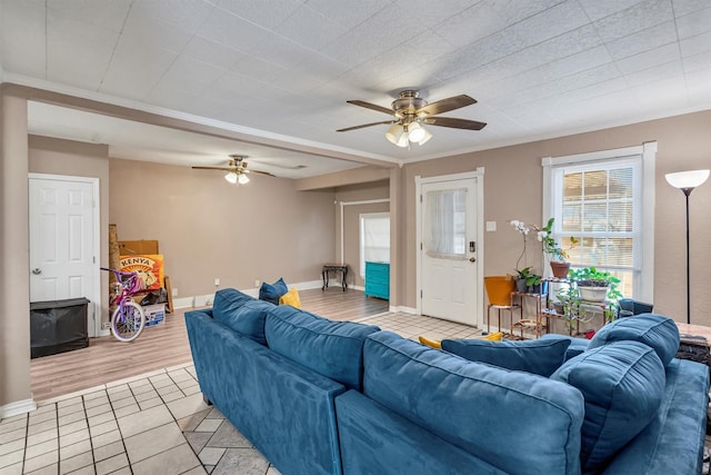 tiled living room featuring ceiling fan and ornamental molding