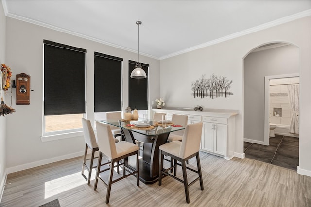 dining area with crown molding and light hardwood / wood-style floors