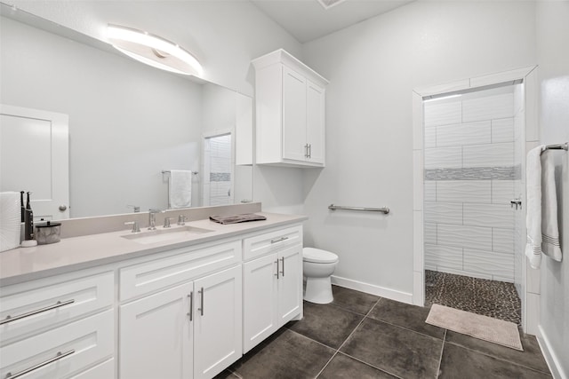 bathroom with vanity, tile patterned flooring, toilet, and a tile shower