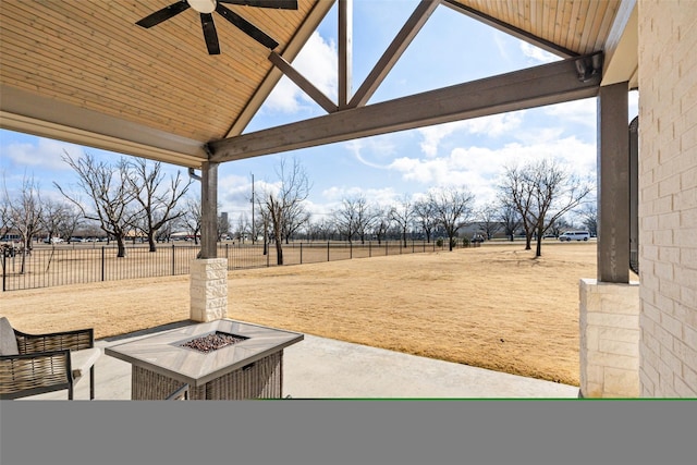 view of yard featuring a rural view, a patio, ceiling fan, and an outdoor fire pit