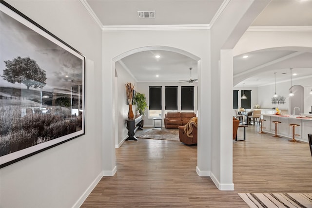 corridor featuring wood-type flooring and ornamental molding