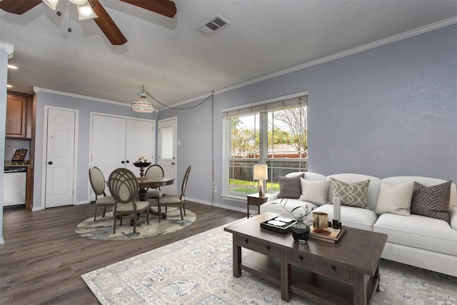 living room with crown molding, a textured ceiling, dark hardwood / wood-style floors, and ceiling fan