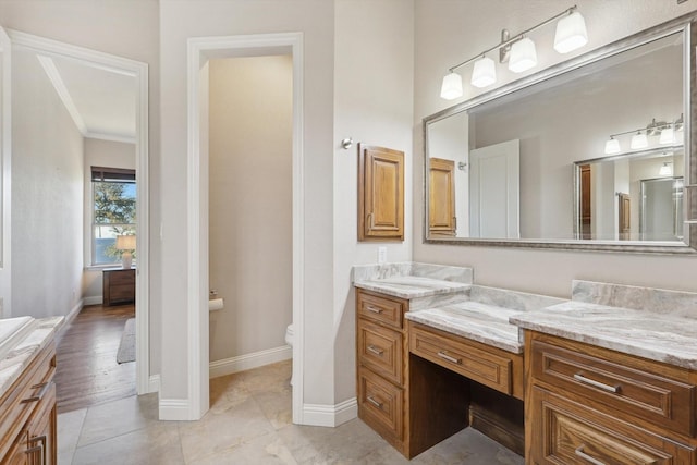 bathroom with vanity, tile patterned flooring, ornamental molding, and toilet