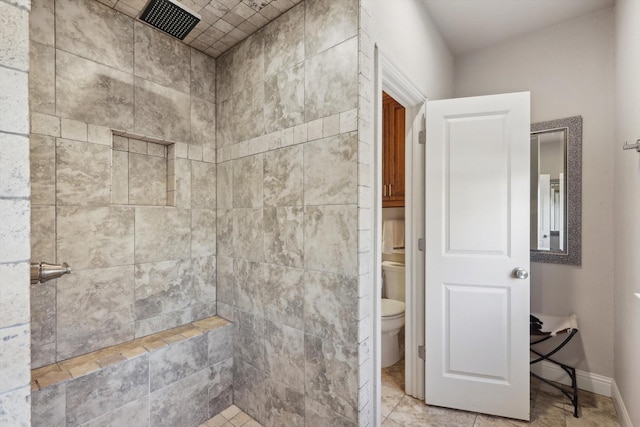 bathroom with toilet and a tile shower