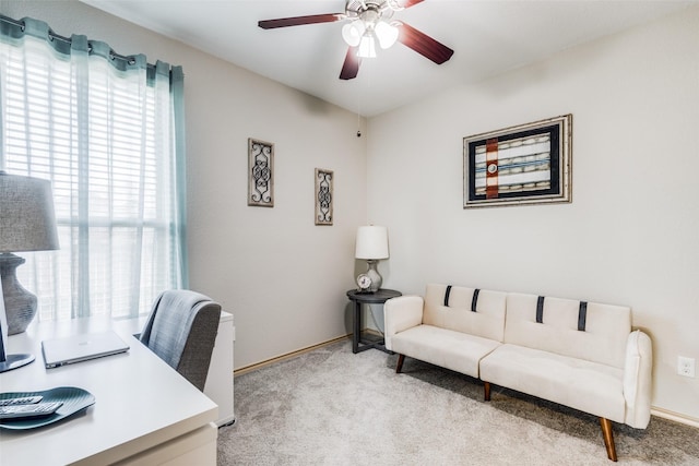 carpeted office space featuring ceiling fan