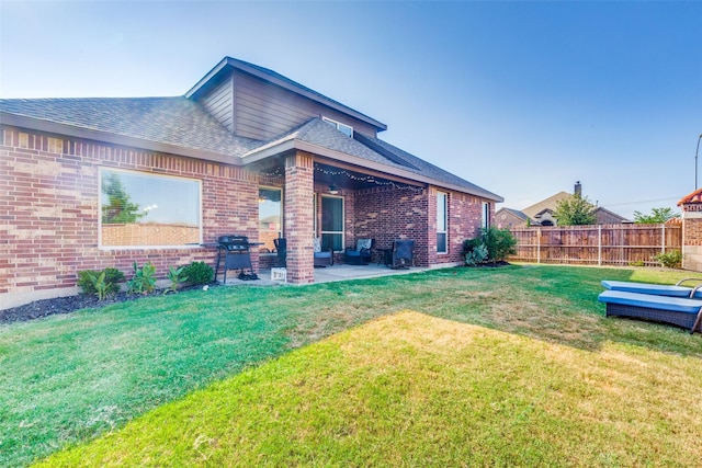 back of house with a patio and a lawn